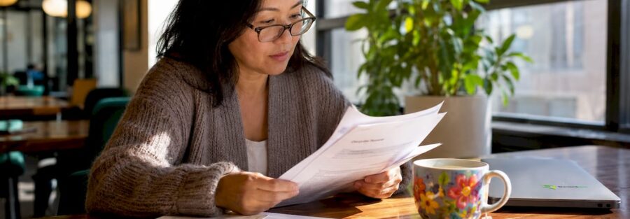 Woman reviewing insurance documents at home desk