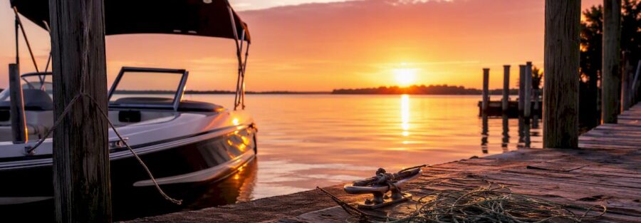 Boat moored at lake dock at sunrise
