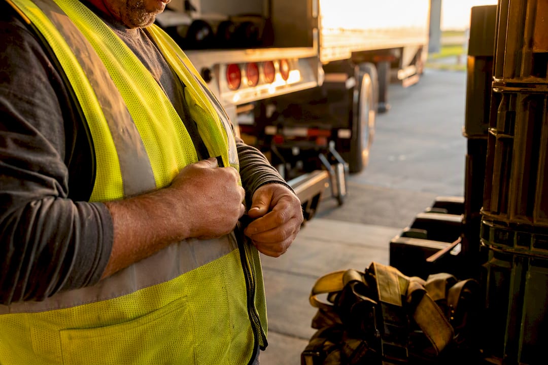 Truck driver attaching safety vest