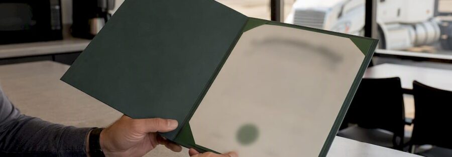 Hands holding certificate holder folder at trucking office