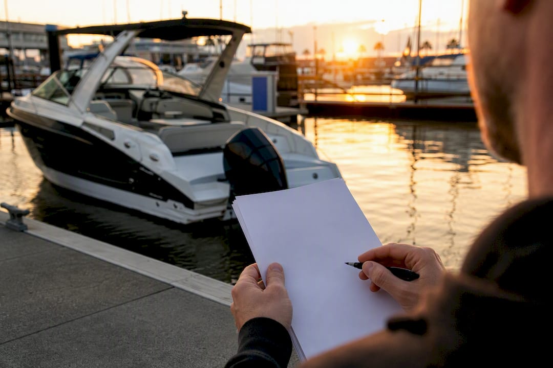 Boat moored and hands holding insurance papers
