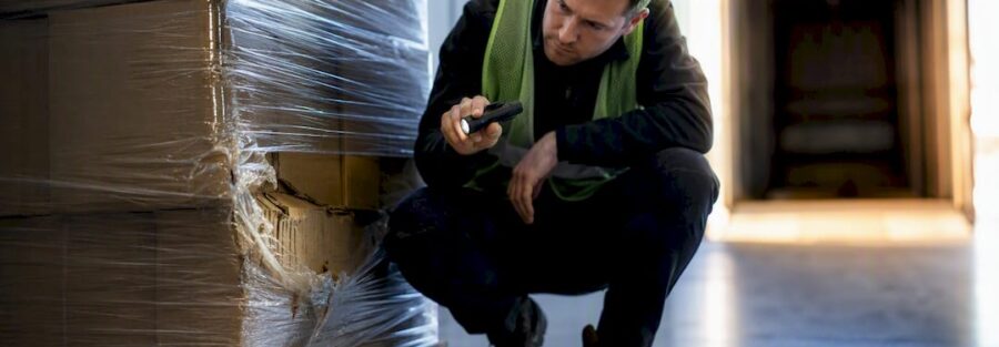 Worker inspecting damaged freight pallet